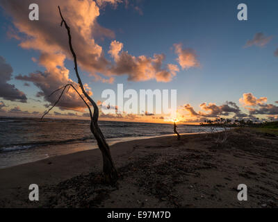Paysage - Lever de soleil derrière une formation nuageuse dans l'arrière-plan avec de longs courriers Bay Beach et la mer des Caraïbes en premier plan. Banque D'Images