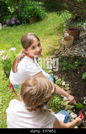 Deux filles jardinage, planter des fleurs ensemble Banque D'Images
