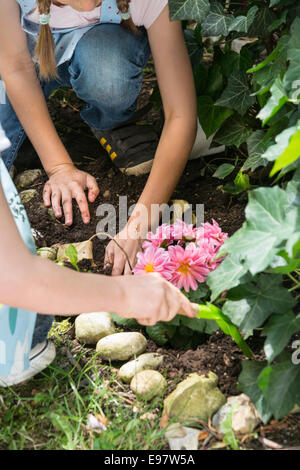 Deux filles jardinage, planter des fleurs ensemble Banque D'Images