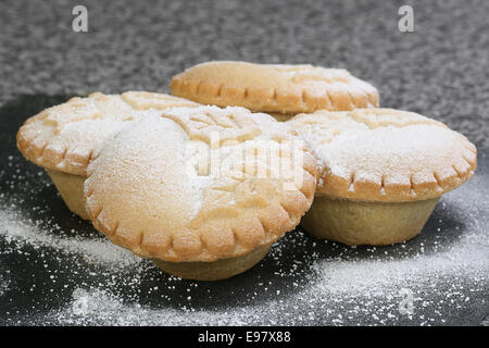 Quatre petits pâtés de noël saupoudrés de sucre glace Banque D'Images