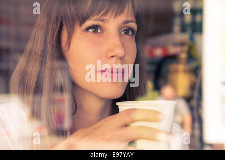 Belle jeune fille de rêve avec une tasse de café. Les tons de couleurs chaudes de droit Banque D'Images