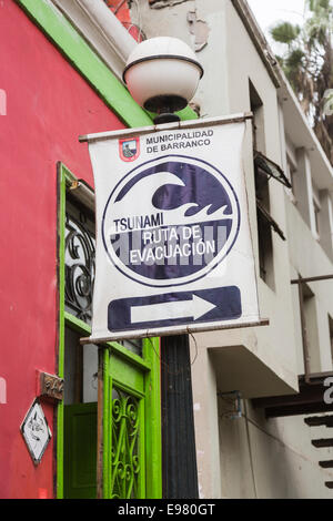 Panneau de route d'évacuation du tsunami à l'extérieur d'une auberge de routards dans la banlieue côtière de Barranco, Lima, Pérou Banque D'Images