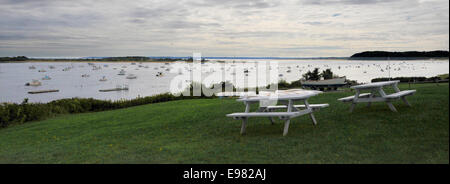 Joli endroit de vacances Voir le produit white tables de pique-nique avec vue sur port plein de bateaux de toutes tailles au crépuscule. Thème de couleurs chaudes. Banque D'Images