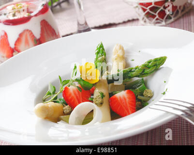 Fraise sain et salade de succulentes asperges vertes et blanches et de tranches de fruits rouges fraises servi dans Banque D'Images