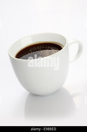 Studio shot of a white chine tasse remplie de café noir riche, sur fond blanc avec la réflexion Banque D'Images