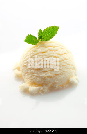 Boule de glace à la vanille garnie de feuilles de menthe verte fraîche sur un fond blanc Banque D'Images