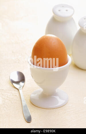 Oeuf frais dans un coquetier avec une cuillère à café prêt pour un petit-déjeuner nutritif sain Banque D'Images