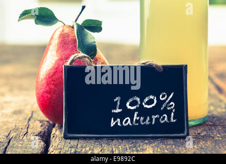 Jus de poire dans une bouteille en verre sur l'affichage à un marché de producteurs avec un panneau disant qu'il est 100 % pure Banque D'Images