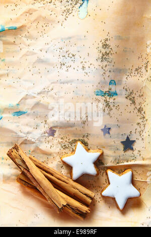 Grunge fond de Noël avec les cookies en forme d'étoile et bâton de cannelle sur les vitraux de papier chiffonné parsemé de petites graines avec copyspace Banque D'Images