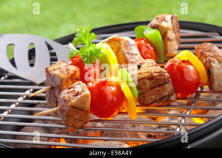 Brochettes de boeuf et de légumes délicieux avec des tranches de tomate et poivrons grillés sur un feu ouvert barbecue à l'extérieur, libre de la grille avec braise ci-dessous Banque D'Images