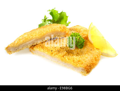 Golden Delicious crumbed ou poulet frit filet de porc couper à travers pour exposer la viande garnie de persil et citron Banque D'Images