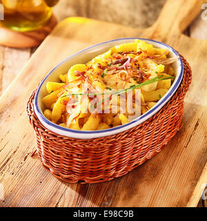 Au service de l'Allemand spatzle ou œuf frit quenelles nouilles dans un plat ovale dans un panier en osier, high angle view Banque D'Images