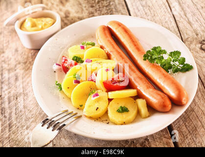 Délicieux déjeuner rustique faite de pommes de terre bouillies et saucisses, garnie de prasley, les tomates, l'oignon et la moutarde Banque D'Images