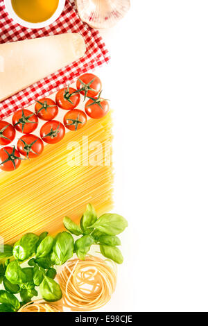 La cuisine fraîche ingrédients pour les pâtes italiennes disposés sur un fond blanc avec le fromage, les tomates, le spaghetti, fettucini, feuilles de basilic frais et d'huile d'olive avec une serviette à carreaux blancs et rouges, copyspace Banque D'Images