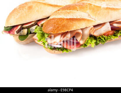 Deux baguettes croustillantes salées savoureuses pour un déjeuner sain, un avec un fromage bleu, figues et bébés épinards, remplissage et l'autre avec du poulet , la tomate et laitue à froufrous,close up on white avec copyspace Banque D'Images