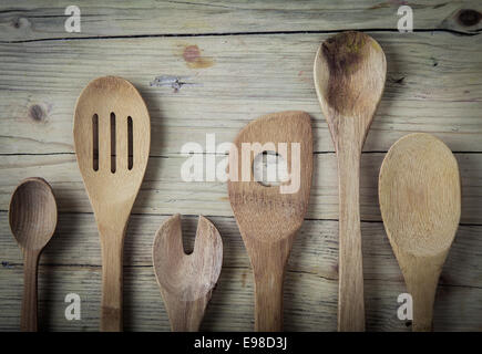 Un assortiment de vieux ustensiles de cuisine en bois posé sur une surface en bois dans un pays prêt à cuire cuisine ou la cuisson d'un repas, Close up vue aérienne Banque D'Images