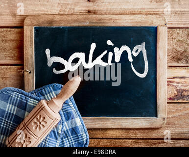 Cuisine de campagne avec un rouleau à pâtisserie en bois sculpté décoratif avec un motif floral sur des gants de allongé sur un vieux millésime school Banque D'Images