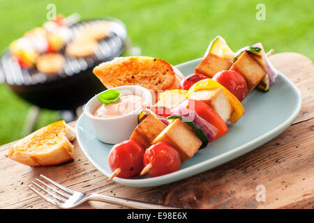 L'extérieur barbecue d'été sur une table avec une brochette de tofu et un grill dans l'arrière-plan Banque D'Images