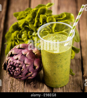 Smoothie de légumes sains avec laitue et artichaut mélangé avec du yaourt servi avec une paille spirale high angle avec des ingrédients frais Banque D'Images