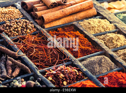 Sélection d'épices séchées dont les grains de poivre, le poivre rouge, le safran et la cannelle dans un vieux bac, imprimantes en bois vue en gros Banque D'Images