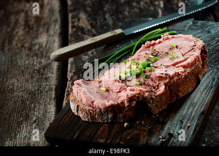 Teewurst allemand fumé salé sur une tranche de pain de seigle garni d'épices et la ciboulette fraîche hachée Banque D'Images