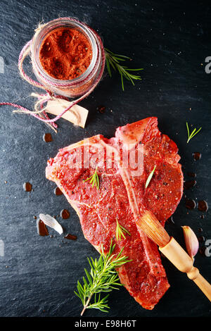 Poudre de la marinade sur la viande fraîche. Isolé sur fond gris Banque D'Images