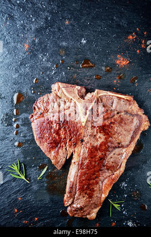 Faire mariner la viande fraîche avec poudre sur Vintage Table. L'ajout d'arômes viande. Banque D'Images