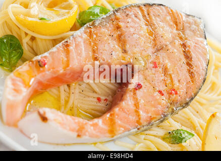 Escalope de saumon grillé avec des linguine pâtes, basilic et citron pour un dîner de fruits de mer, cuisine gastronomique italienne vue rapprochée et la texture Banque D'Images