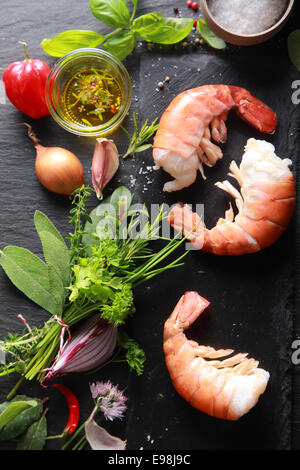 La chair de crevettes délicieux avec des ingrédients, pour la cuisson, isolé sur fond de table noir Banque D'Images