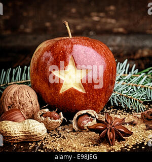 Pomme Rouge sculpté avec Macro Star, écrous sur côté, sur table en bois. Maison de fruits. Banque D'Images