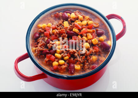 Près de savoureux plat principal Recette sur pot rouge isolé sur fond blanc. Banque D'Images