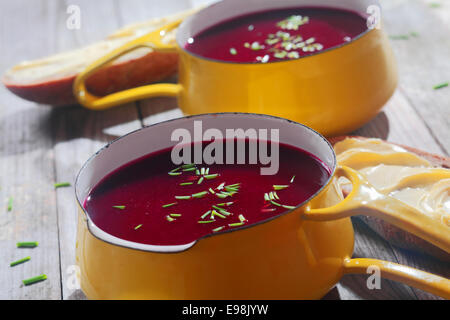 Close up Snacks Soupes Betteraves jaune sur le bol avec poignée. Parfait pour le pain avec propagation sur le côté, mis sur table en bois. Banque D'Images