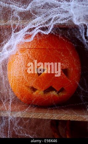 Spooky Spider web couverts jack-o-lantern formé à partir d'une orange fraîche dans un Scary Halloween background Banque D'Images