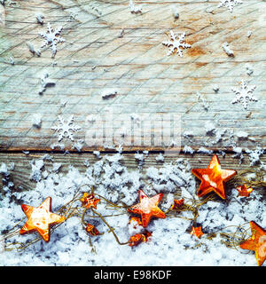 Golden stars avec de la neige et de la chute d'un flocon de décoration de Noël rustique avec fond copyspace pour vos voeux de Noël, format carré Banque D'Images