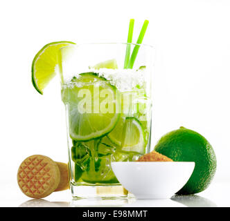 Caipirinha isolé sur fond blanc, avec un mortier et le sucre brun et les tranches de citrons verts Banque D'Images