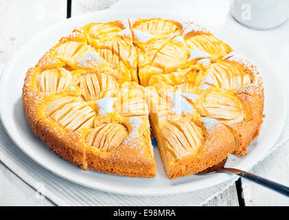 Portrait d'une tarte aux pommes fraîchement tranchés prêts à servir sur une assiette blanche Banque D'Images