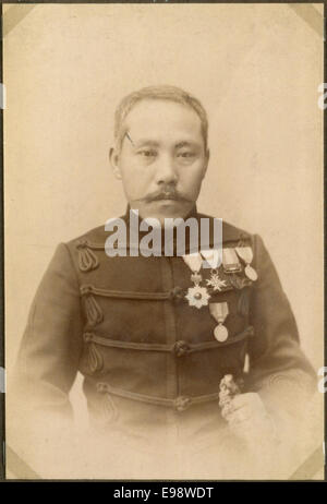 Cette photographie vintage représente un officier japonais en uniforme, probablement du début du XXe siècle, représentant la tenue militaire portée pendant la période au Japon, mettant en valeur le design détaillé de l'uniforme. Banque D'Images