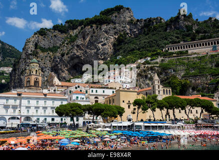 Les vacanciers et les habitants de profiter de la plage bordée d'un parasol à l'Amalfi. Banque D'Images