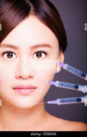 Belle femme asiatique obtient l'injection dans son visage. Banque D'Images