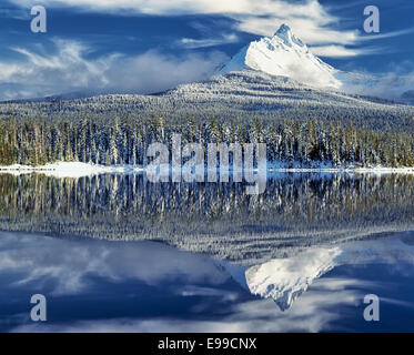 Centre de l'Oregon's Mt Washington émerge des nuages pour révéler la première neige en hiver et le soir la réflexion dans Grand Lac. Banque D'Images