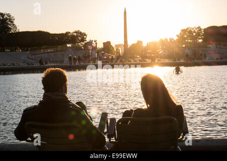 Couple sitting at lac de plaisance dans le jardin des Tuileries que les couchers de soleil derrière la Place de la Concorde sur un étés juin en fin de soirée,Paris Banque D'Images