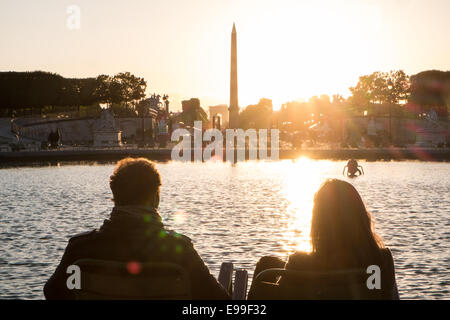 Couple sitting at lac de plaisance dans le jardin des Tuileries que les couchers de soleil derrière la Place de la Concorde sur un étés juin en fin de soirée,Paris Banque D'Images