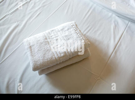 Pile de serviettes blanches sur le lit Banque D'Images