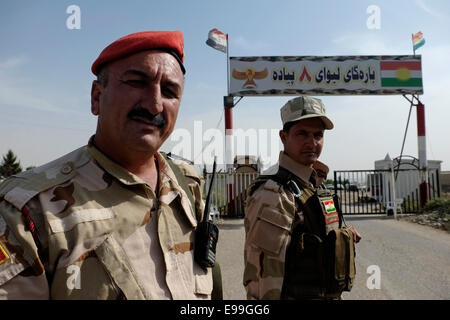 Des membres des forces militaires kurdes Peshmerga de la région autonome du Kurdistan d'Irak gardent la garde à l'entrée de leur camp près de la ville de Zakho, dans le nord de l'Irak Banque D'Images
