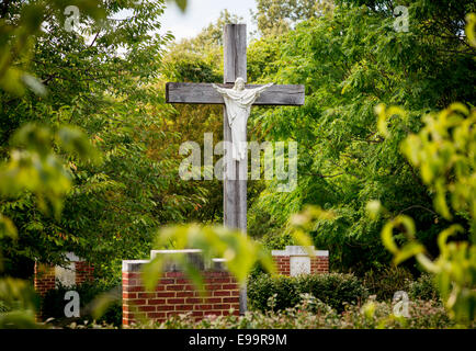 Statue de Jésus sur croix dans jardin arboré Banque D'Images