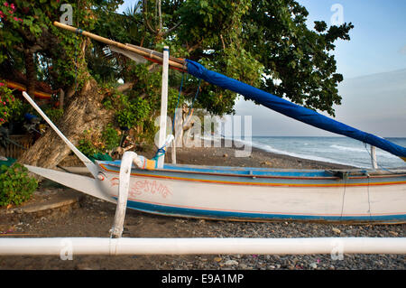 Un bateau repose sur la plage de sable d'Amed, un village de pêcheurs à l'Est de Bali. Amed est une longue bande côtière de villages de pêche en E Banque D'Images