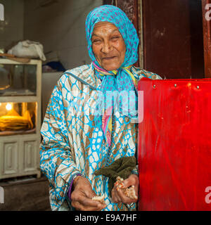 Vieille dame souriant avec du pain au Maroc Banque D'Images