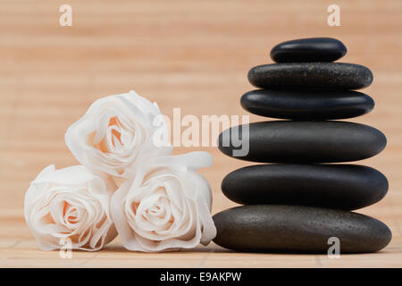 Close up roses et une pile de cailloux noirs Banque D'Images