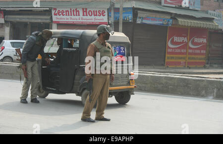 Srinagar, Cachemire sous administration indienne. 23 octobre, 2014. Un policier indien vérifie les passagers véhicules pendant une journée de grève comme magasins et commerces sont restés fermés au Cachemire en raison d'une grève pour protester contre les séparatistes a parrainé une visite dans la région par le Premier Ministre, M. Narendra Modi Crédit : Sofi Suhail/Alamy Live News Banque D'Images
