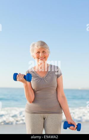 Femme faisant ses exercices à la plage Banque D'Images